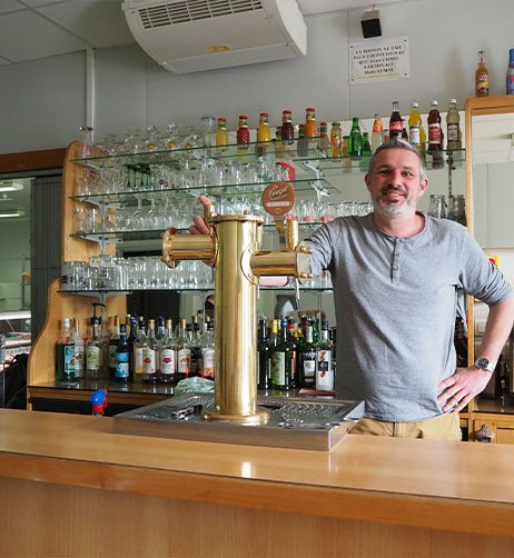 le g&eacute;rant derri&egrave;re le bar du relais.